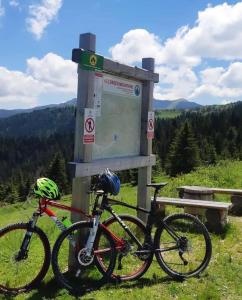 duas bicicletas estacionadas ao lado de uma placa numa colina em Čakorski Konaci em Berane