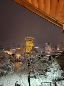 uma vista de uma cidade à noite coberta de neve em Sanli em Mestia