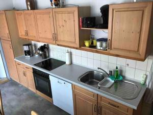 a kitchen with wooden cabinets and a sink at Thüdinghäuser Gästehaus - Monteurzimmer in Moringen