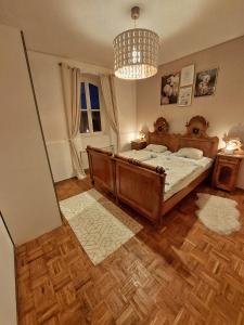 a bedroom with a wooden bed and a chandelier at Wohnen im Grünen in Graz