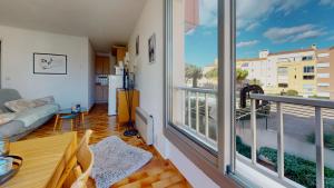 een woonkamer met een groot raam en een bank bij Beau studio, plage, port. in Cap d'Agde