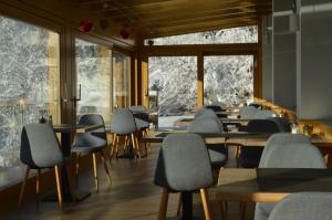 a row of tables and chairs in a room with windows at Jägerhotel in Annenheim