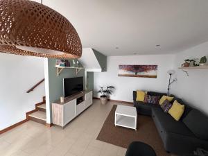 a living room with a couch and a television at Casa Milan in Puerto Calero
