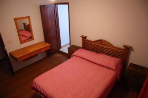 a small bedroom with a bed and a mirror at EL CAPIRO in Mineral del Chico