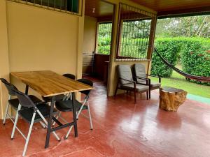 a dining room with a wooden table and chairs at Casita el jardin in Bijagua
