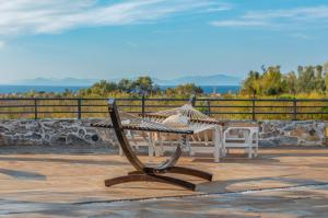 un banc et une table sur une terrasse dans l'établissement Villa Neveda mit Tennis und Basketballplatz, à Datça