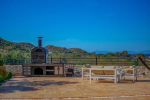 eine Terrasse mit einem Kamin, einem Tisch und Stühlen in der Unterkunft Villa Neveda mit Tennis und Basketballplatz in Datca
