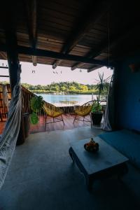 een kamer met een bed en een tafel met uitzicht op een rivier bij Casinha Azul Caraíva - casa completa na beira do Rio in Caraíva