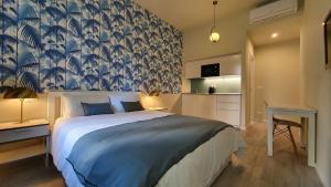 1 dormitorio con 1 cama grande y papel pintado azul y blanco en Blue Palm Jungle Studio Self Checkin Design, en Milán