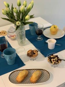 una mesa con platos de comida y un jarrón de flores en Blue Palm Jungle Studio Self Checkin Design, en Milán