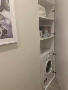 lavadero con lavadora en un armario en Blue Palm Jungle Studio Self Checkin Design, en Milán