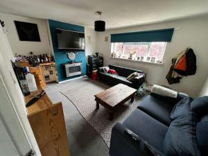 a living room with a blue couch and a table at Spacious Rooms close to Aylesbury Centre - Free Fast WiFi in Buckinghamshire