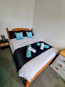 um quarto com 2 camas e almofadas azuis em Spacious Rooms close to Aylesbury Centre - Free Fast WiFi em Buckinghamshire
