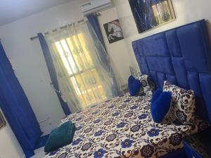 a bedroom with a blue bed and a window at Luxe et confort a ngor dans un quartier très accessible in Ngor