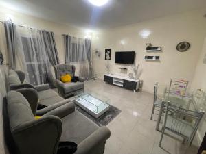a living room with two couches and a television at Luxe et confort a ngor dans un quartier très accessible in Ngor