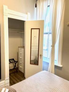 a bedroom with a bed and a mirror and a window at Lakeview Getaway in Chicago