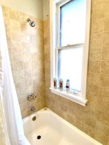 a bathroom with a bath tub and a window at Spacious Historic Apartments In Lakeview Chicago - Walk to Wrigley, Nightlife, Shops, Hospitals in Chicago