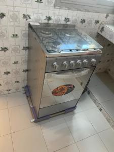 a stove in a kitchen with a pizza in the oven at Luxe et confort a ngor dans un quartier très accessible in Ngor