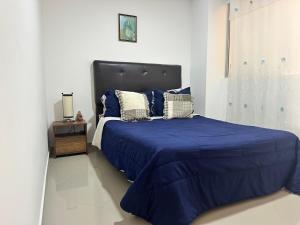 a bedroom with a large bed with blue sheets and pillows at Hermoso apartamento lindas vistas in Santuario