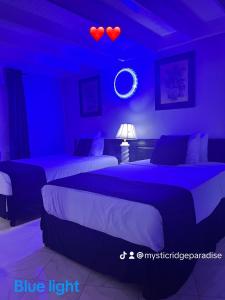 a bedroom with two beds and a blue light at Mystic Ridge Paradise in Ocho Rios
