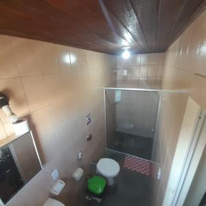 a small bathroom with a toilet and a shower at Pousada Miramar in Marataizes