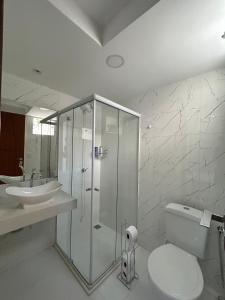a bathroom with a shower and a toilet and a sink at Boa Beach House in Porto Seguro