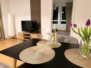 a living room with a black table with two plates on it at Gemütliche 2-Zimmer Wohnung im Zentrum in Neumünster