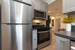 a kitchen with a stainless steel refrigerator and microwave at Fun 5 Bedroom House Near DTLA in Los Angeles