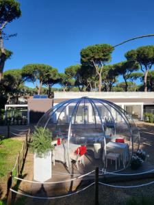 un dôme en verre avec des tables et des chaises dans un parc dans l'établissement VillaLume, à Marina di Castagneto Carducci
