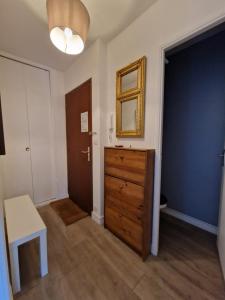 Zimmer mit einer Kommode, einem Spiegel und einer Tür in der Unterkunft Appartement charmant bord de mer in Cabourg