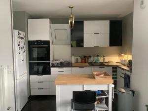 cocina con armarios blancos y encimera de madera en Appartement avec roof top, en Saint-Brice-sous-Forêt