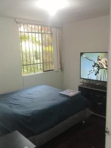 1 dormitorio con 1 cama y TV. en Acogedora Habitacion Independiente, en Lima