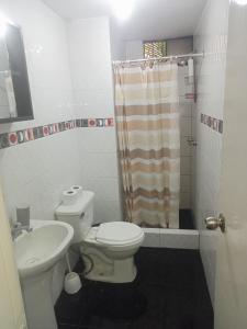 y baño con aseo, lavabo y ducha. en Acogedora Habitacion Independiente, en Lima