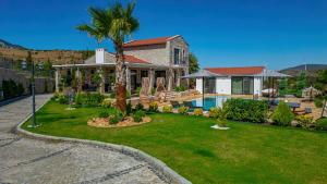 una casa con una palma e una piscina di Villa Pamira mit Basketballplatz a Eski Datca