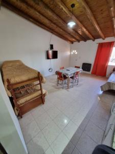 uma sala de estar com uma mesa e uma cama em Cuarta División Apartments em Malargüe