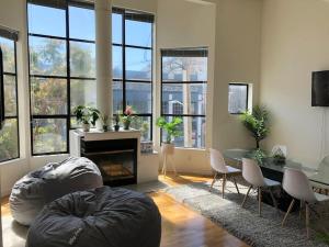 un soggiorno con ampie finestre, tavolo e sedie di Bright Spacious & Comfortable Hayes Valley Condo a San Francisco