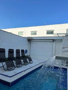 a patio with chairs and a swimming pool at Boa Beach House in Porto Seguro