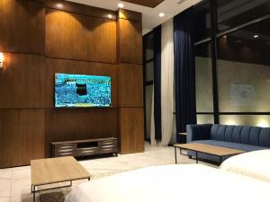 a bedroom with a bed and a tv on a wall at SAAF RESORT in Al Ghuţghuţ