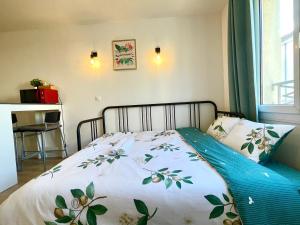a bedroom with a bed with a floral bedspread at Cosy studio near Disneyland Paris, well located 10minutes in Bussy-Saint-Georges