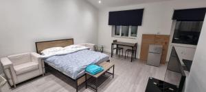 ein Schlafzimmer mit einem Bett, einem Tisch und Stühlen in der Unterkunft Ilford Towncentre Large Studio in Ilford