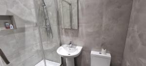 ein Badezimmer mit Dusche, Waschbecken und Toilette in der Unterkunft Ilford Towncentre Large Studio in Ilford + 3 Fotos