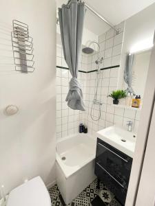 a bathroom with a tub and a toilet and a sink at Cosy studio near Disneyland Paris, well located 10minutes in Bussy-Saint-Georges