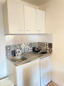 a kitchen with white cabinets and a sink at Cosy studio near Disneyland Paris, well located 10minutes in Bussy-Saint-Georges