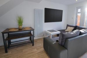 een woonkamer met een bank en een tafel bij Contractors, Medical staff, Relocators, Families- 5 Bedroom 3 bathroom house- 2min walk to L&D in Luton