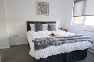 een slaapkamer met een groot bed en een deken bij Contractors, Medical staff, Relocators, Families- 5 Bedroom 3 bathroom house- 2min walk to L&D in Luton