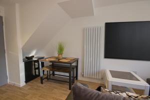 een woonkamer met een tafel en een tv aan de muur bij Contractors, Medical staff, Relocators, Families- 5 Bedroom 3 bathroom house- 2min walk to L&D in Luton