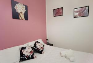 um quarto com uma cama branca e 2 almofadas em Luxury Sisters House "La Buganvilla" em Catânia