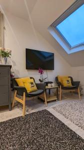 uma sala de estar com 2 cadeiras e uma televisão de ecrã plano em Sidney Grove B&B em Newcastle upon Tyne
