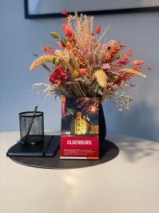un jarrón lleno de flores sobre una mesa en Sonnige Dachwohnung nahe dem Klinikum., en Oldenburg