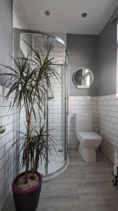 a bathroom with a toilet and a potted plant at Sidney Grove B&B in Newcastle upon Tyne